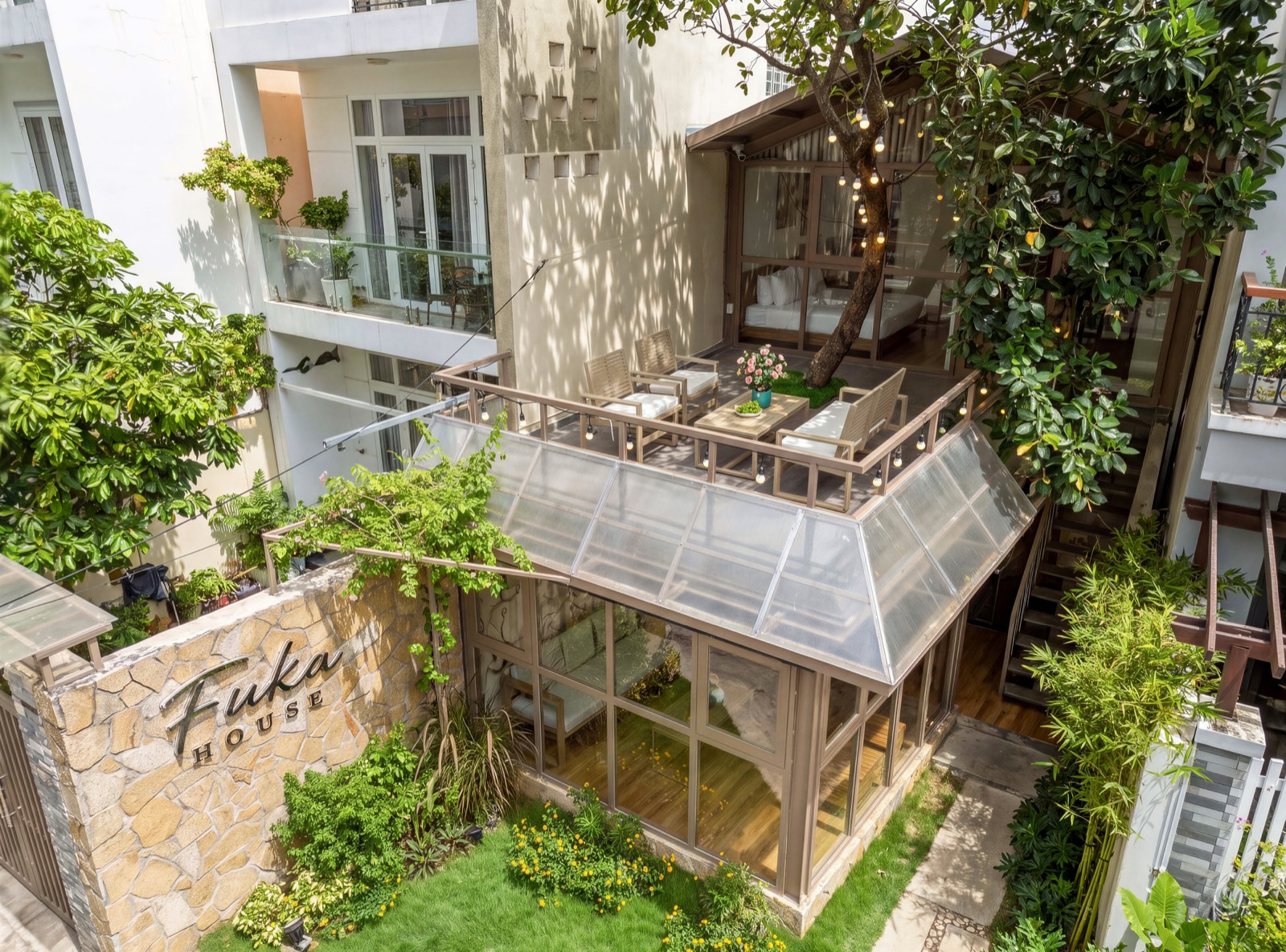 Fuka House seen from above in daylight — terrace, glass roof and garden