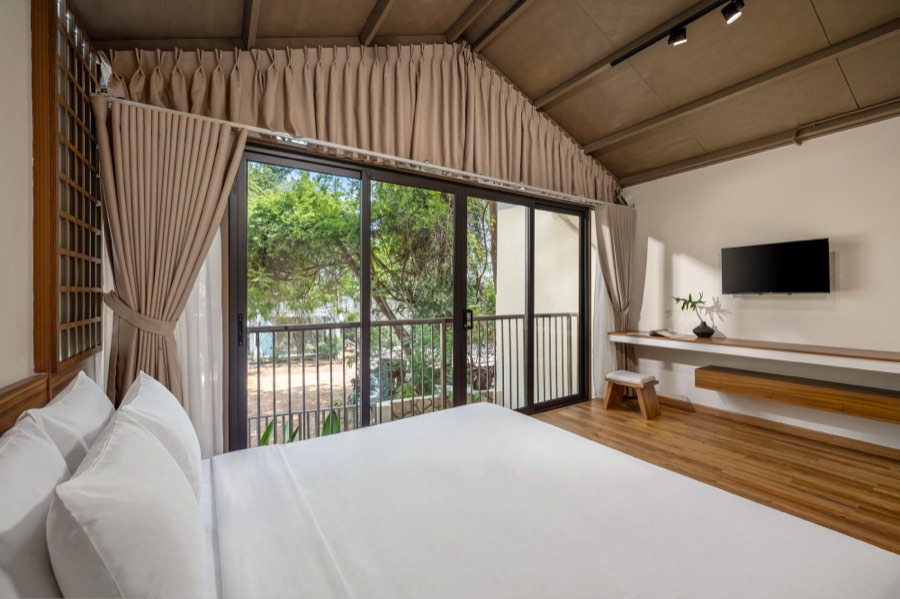 Bedroom One with the balcony doors open to the trees