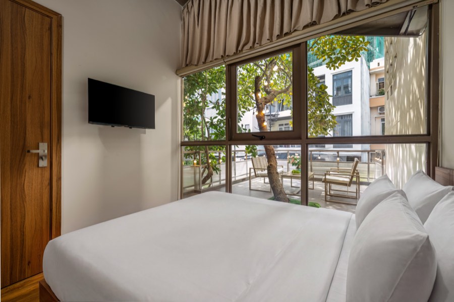 The terrace tree seen from the bed — bedroom two at Fuka House, Da Nang