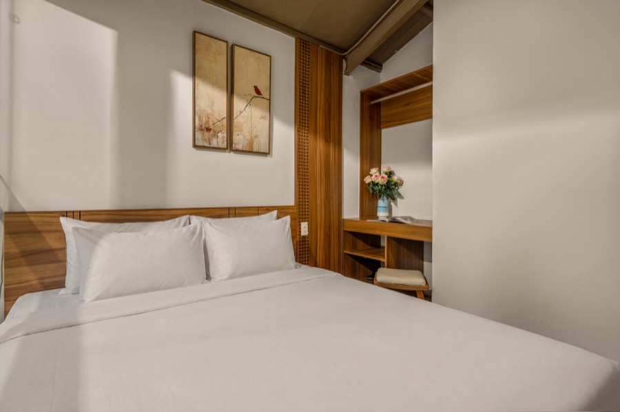 Bird prints above the bed, beside the wardrobe alcove — bedroom two at Fuka House, Da Nang