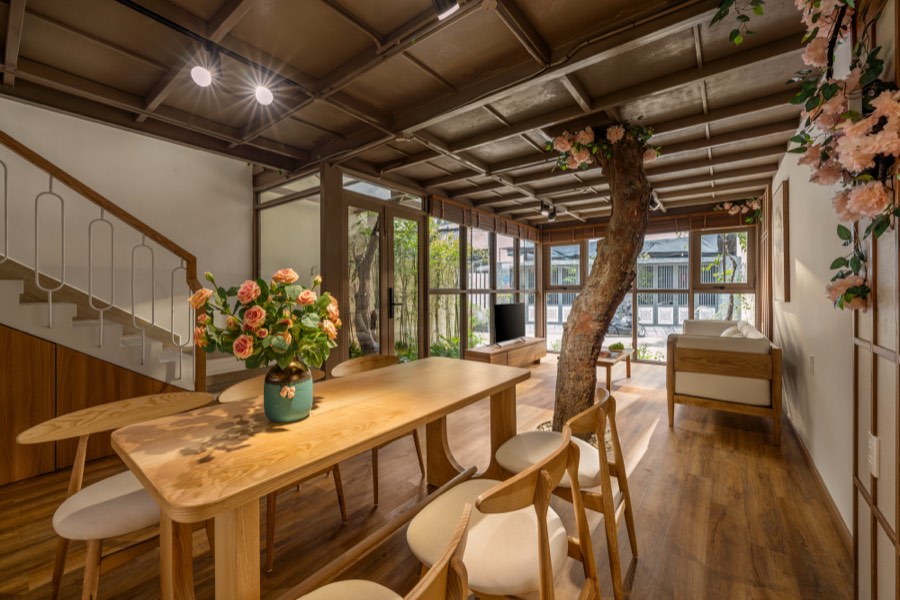 Dining table for six beneath the timber ceiling, beside the staircase