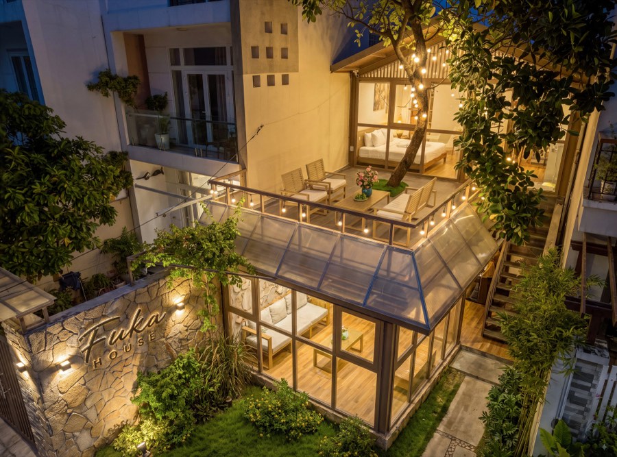 The house at dusk, terrace and garden room lit with lanterns — exterior at Fuka House, Da Nang