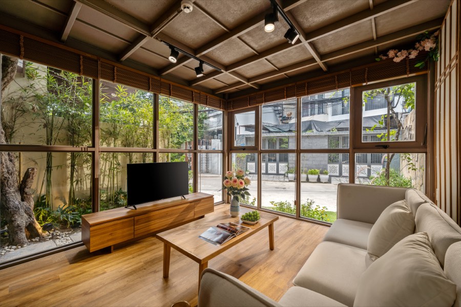 Living room with full-height glass looking onto a bamboo courtyard
